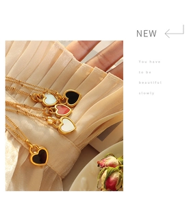 Détails de pendentifs en forme de cœur en nacre sur des chaînes dorées en titane