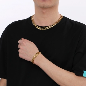Polished gold Figaro chain necklace and bracelet set shown on model for men