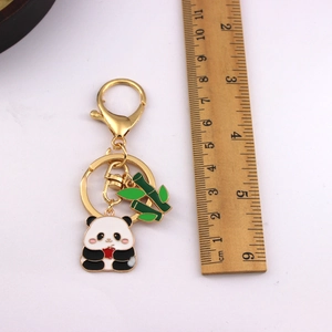 Detailed view of 10.5cm panda keychain with bamboo charm next to a wooden ruler