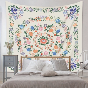 Bohemian mandala floral tapestry hanging on a bedroom wall with a cream base color