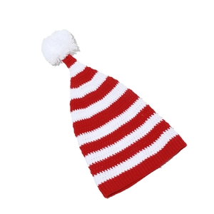 Close-up of the red and white striped knit texture and soft pom-pom on the Christmas hat