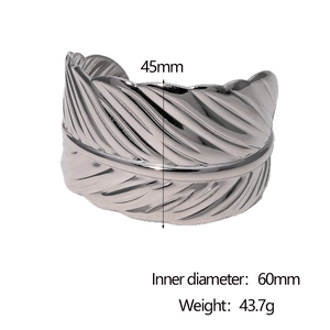 Macro detail of silver stainless steel cuff bracelet with fine feather texture and patterns