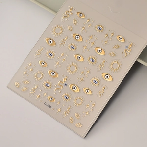 Detail of 5D embossed nail stickers with gold serpent and evil eye mystical designs