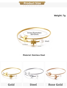 Detail of stainless steel spiral bangles featuring snowflake moon charms and pearls