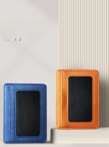 Detail of lychee textured PU leather card holders in blue and orange with stitching