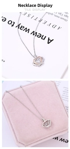 Detail of crown pendant with rose gold heart and sparkling stone on velvet box