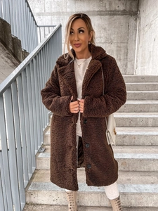 Detail of plush faux fur texture on a long dark brown teddy coat with button closure