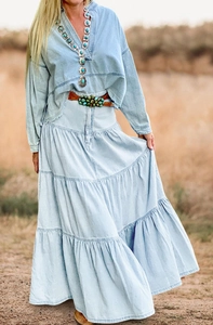 Dettaglio della gonna lunga in denim a balze sovrapposte con lavaggio vintage effetto usurato