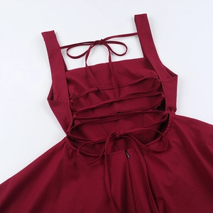 Detail view of burgundy backless dress showing crisscross straps and bow tie design
