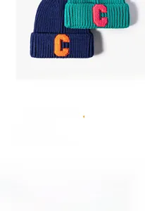 Close-up of knit beanie with 'C' patch embroidery in navy blue and teal colors