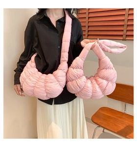 Detail of pink quilted dumpling bags showing soft nylon texture and cloud-like design