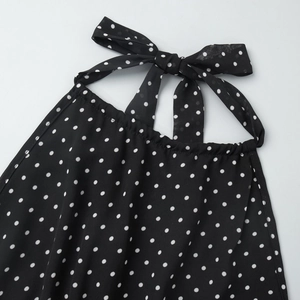 Close-up of black polka dot halter neck dress with adjustable bow tie detail