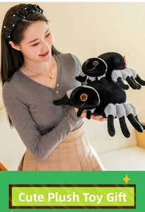 Close-up of plush spider doll in large and small sizes with grey legs and orange eyes