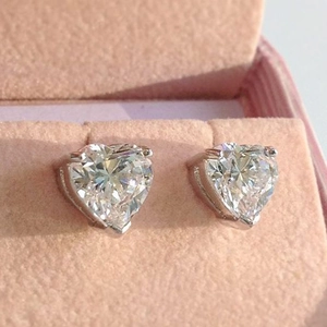 Close-up of heart-cut colorful zircon studs in a pink velvet jewelry box