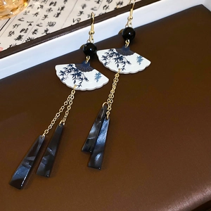Détail de boucles d'oreilles en résine en forme d'éventail avec motif de bambou bleu
