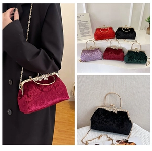 Detail of vintage velvet evening bag with ornate metal clasp and chain strap