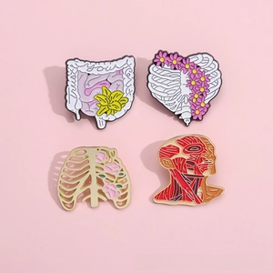 Détail de 4 broches émaillées anatomiques avec motifs de cœur, côtes et fleurs vintage