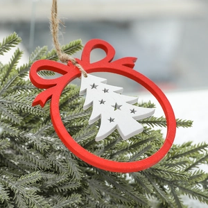 Red wooden Christmas ornament with star and tree cutout hanging on pine branches