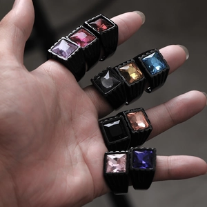 Detailed close-up of multiple vintage stainless steel rings with colorful square gemstones
