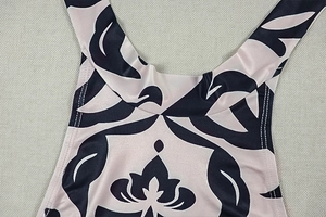 Close-up of pink floral jumpsuit neckline showing double stitching and halter straps