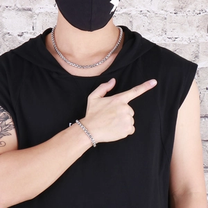 Set collana e bracciale in acciaio al titanio lucido argento indossato da un modello