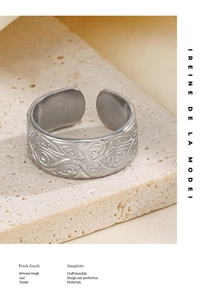 Close-up of vintage stainless steel ring with embossed patterns on stone base