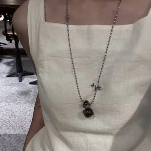 Tiger eye stone horse pendant necklace worn on a model with beige square neck top