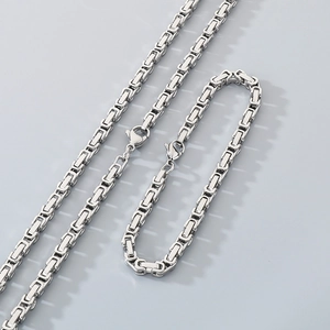 Detailed view of silver Byzantine style stainless steel chain necklace and bracelet set