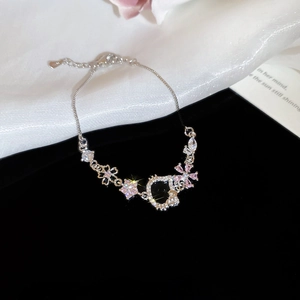 Macro shot of S925 silver bracelet featuring pink zircon heart and cat charm detail