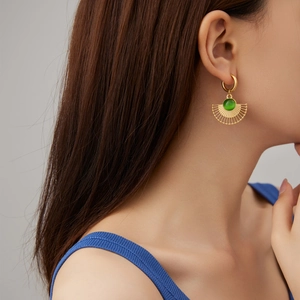 Élégantes boucles d'oreilles pendantes éventail dorées avec pierre verte sur mannequin