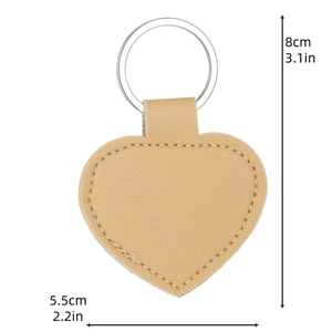 Detail of light brown heart-shaped PU leather keychain with stitching and silver ring