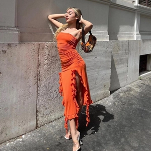 Detail of sexy orange bodycon strapless dress featuring ruffled textures and high side slit