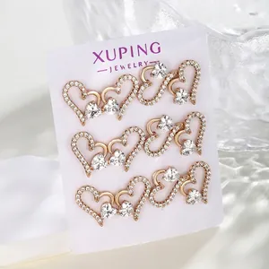 Three pairs of heart-shaped 18K gold plated earrings with zircon crystals on display card