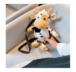 Detail showing the adjustable black shoulder strap and soft plush texture of cow bag
