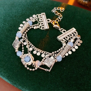 Detail of vintage multi-layer bracelet with blue beads on dark green velvet