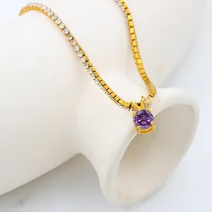 Detail of a gold-plated necklace featuring a round purple gemstone and a zircon tennis chain
