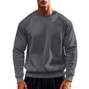 Detail of grey crewneck sweatshirt featuring corduroy patchwork and a chest pocket