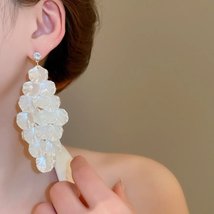 Close-up of elegant long shell petal tassel earrings with rhinestones on model ear