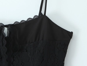 Close-up of black lace fabric texture and delicate neckline detail on the summer dress