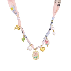 Detail of pink floral silk ribbon chain with assorted gold heart and cactus charms