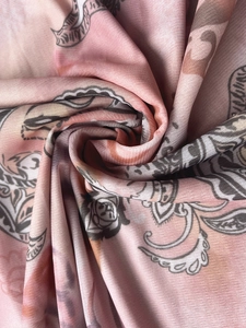 Detail of pink mesh fabric with vintage paisley floral print and fine textile texture