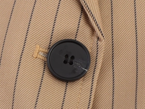Detailed macro view of the striped linen-blend blazer with black four-hole resin buttons