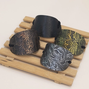 Detail of vintage embossed leather hair ties in black, bronze, gold and silver tones