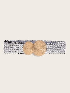 Close-up of interlocking gold round buckles on a silver sequin wide elastic waist belt