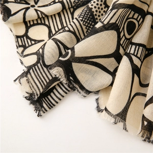Detailed macro view of cotton linen scarf texture with floral patterns and tassel fringe