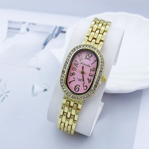 Detail of pink oval dial with crystal-encrusted bezel and gold metal strap on display