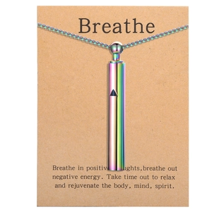 Macro detail of rainbow titanium steel meditation whistle pendant on a brown gift card