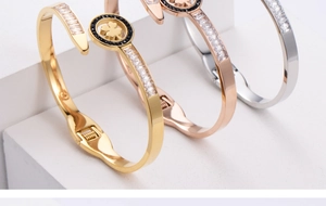 Vista macro di bracciali a quadrifoglio in oro, argento e oro rosa con zirconi e cerniera
