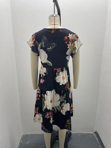Macro detail of the floral butterfly print and tiered ruffle hem on the black dress