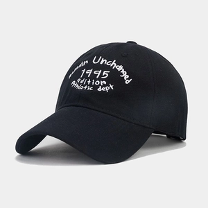 Dettaglio del ricamo bianco sul tessuto di cotone nero di un cappellino da baseball